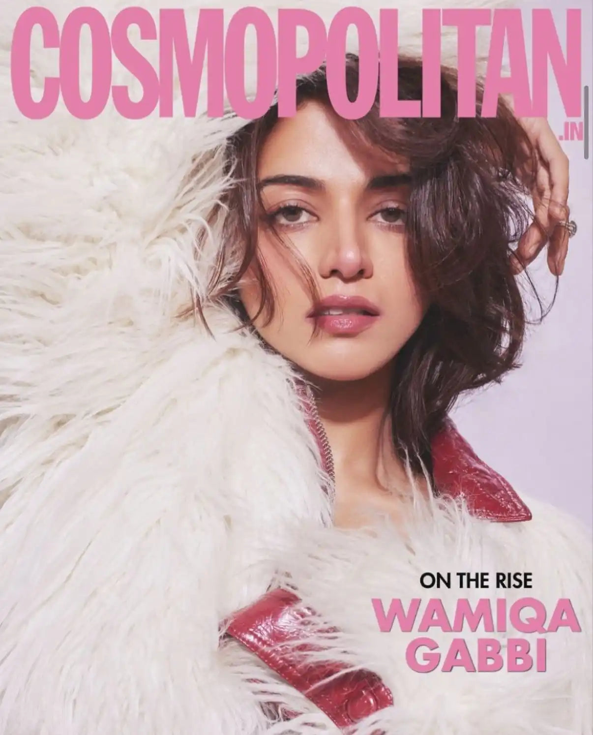 Cosmopolitan magazine cover featuring a model wearing white feathers and a red collar.